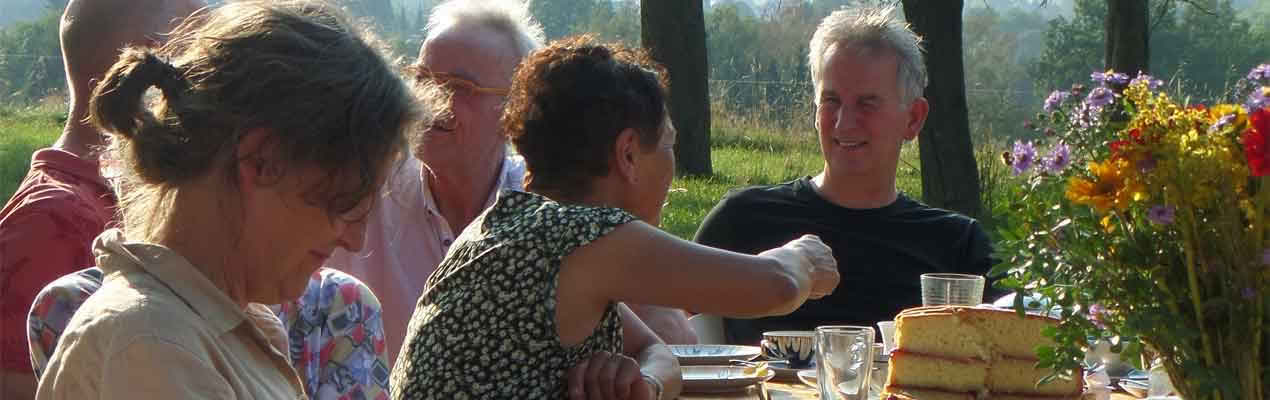 Vor der Esswerkstatt sitzende Menschen